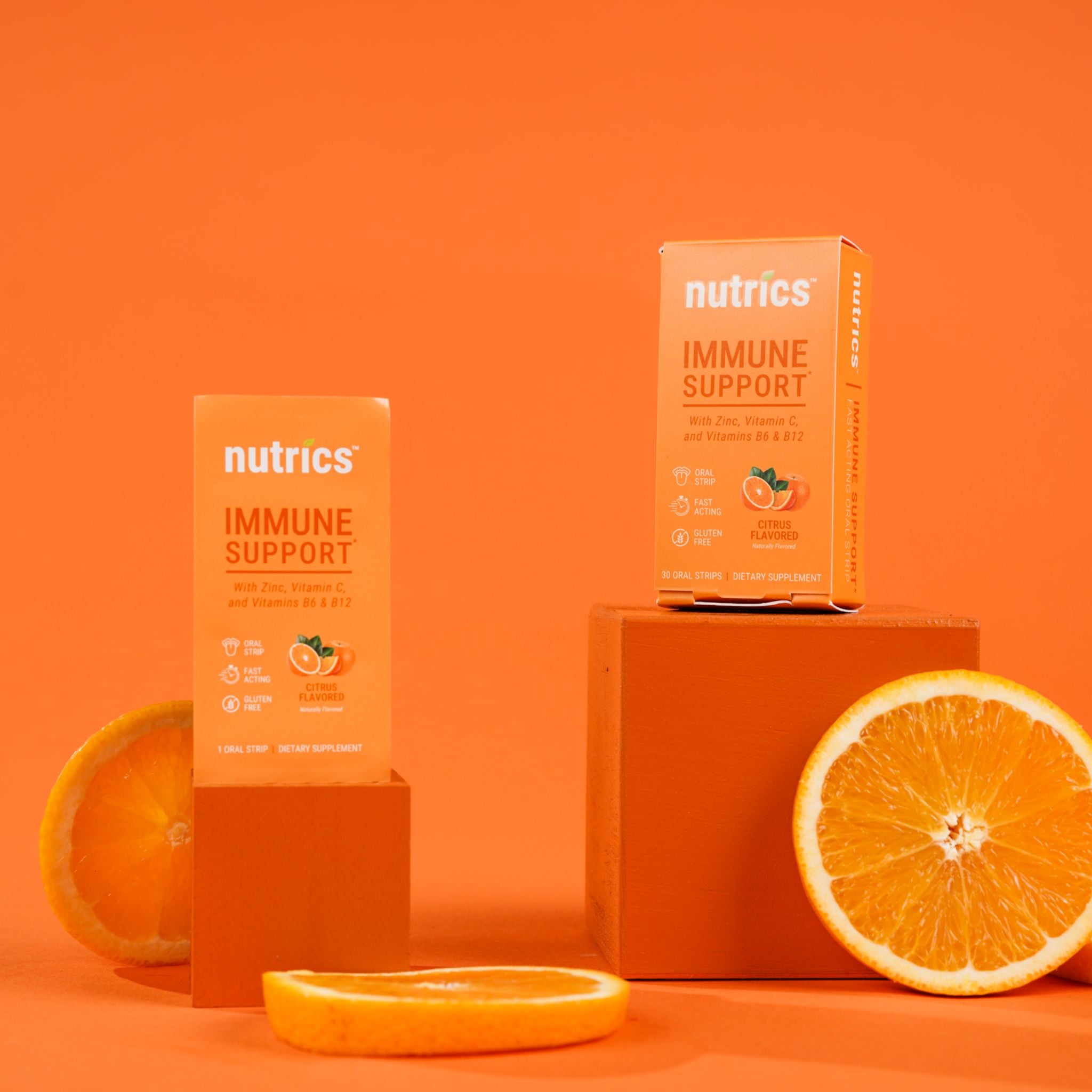 Nutrics immune support product packaging on an orange background with oranges.